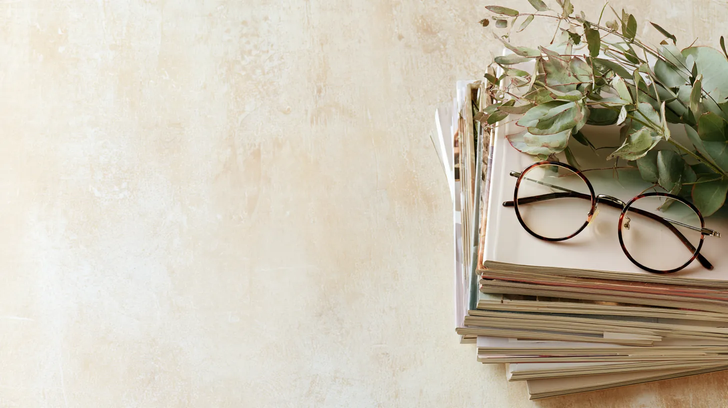 Top-down flat lay of modern magazines, reading glasses and eucalyptus for the lendgo loans guides library
